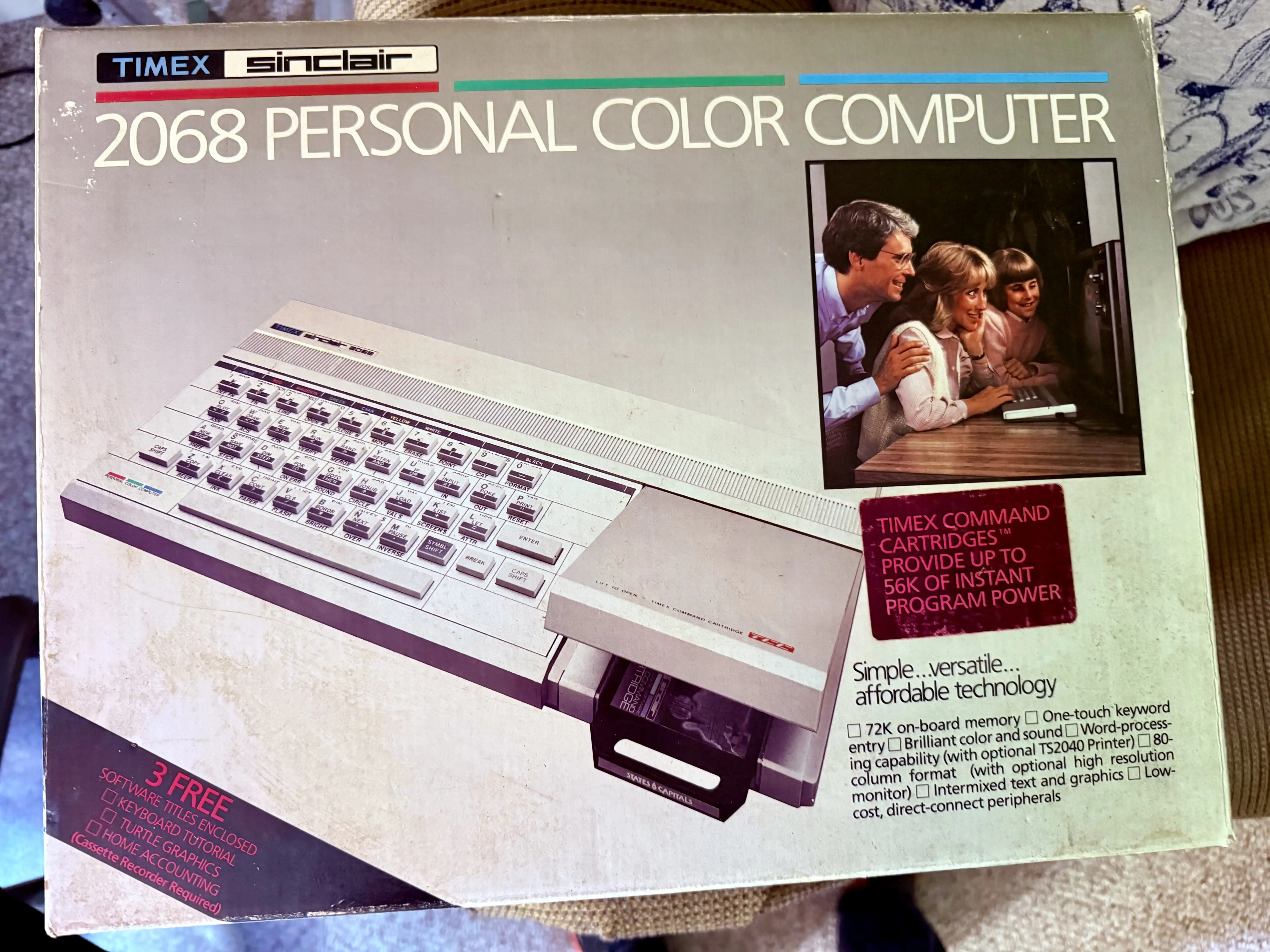 Look at this family. Dad in his dress shirt, mom leaning in over his shoulder, kid hovering at the edge of the frame, all of them staring at a 2068 like it&rsquo;s about to recite scripture. This was the home-computing pitch in 1983.