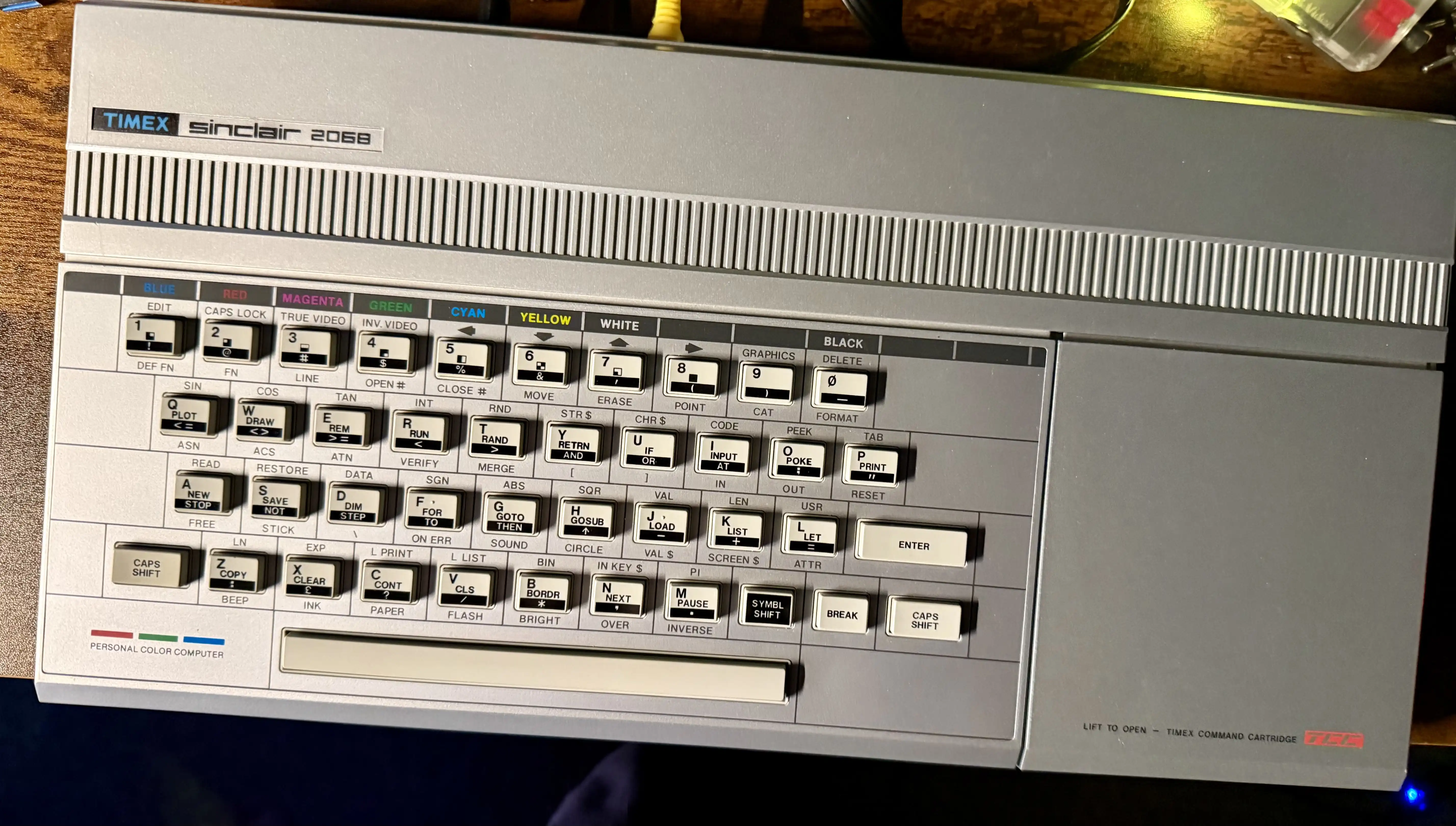 Every key has three or four labels printed on it. Base keyword, symbol-shifted alternate, caps-shifted version, function. PLOT, ASN. DRAW, ACS. REM, VERIFY. The colors along the top are how you select INK and PAPER colors in a single keypress.